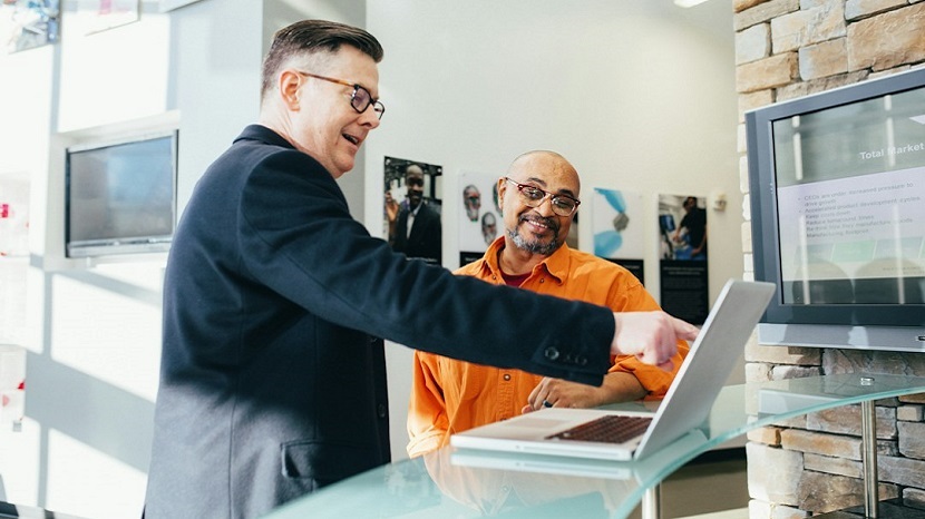 Two sales leaders looking at a laptop utilizing sales enablement tools